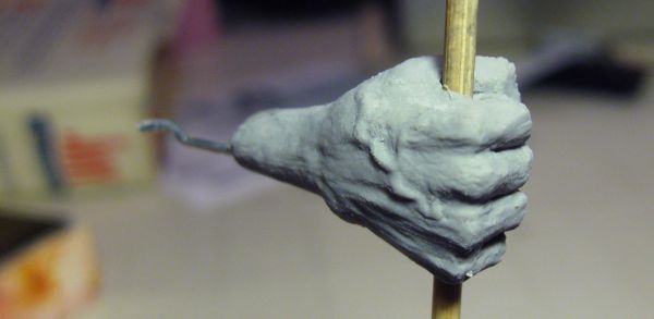 Humanoid sculpture, right hand with a walking stick